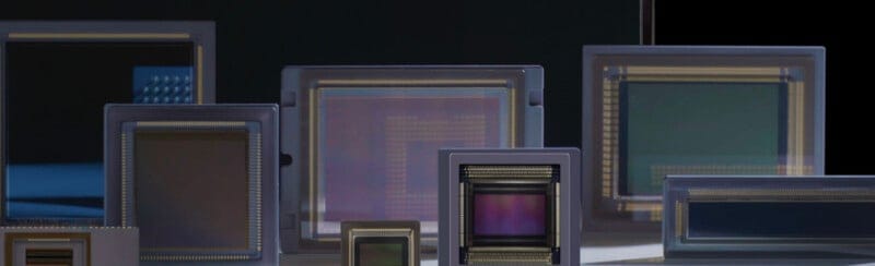 Image 2: Several rectangular image sensors of varying sizes are displayed upright in front of a dark background, showcasing their reflective surfaces and intricate internal circuitry.