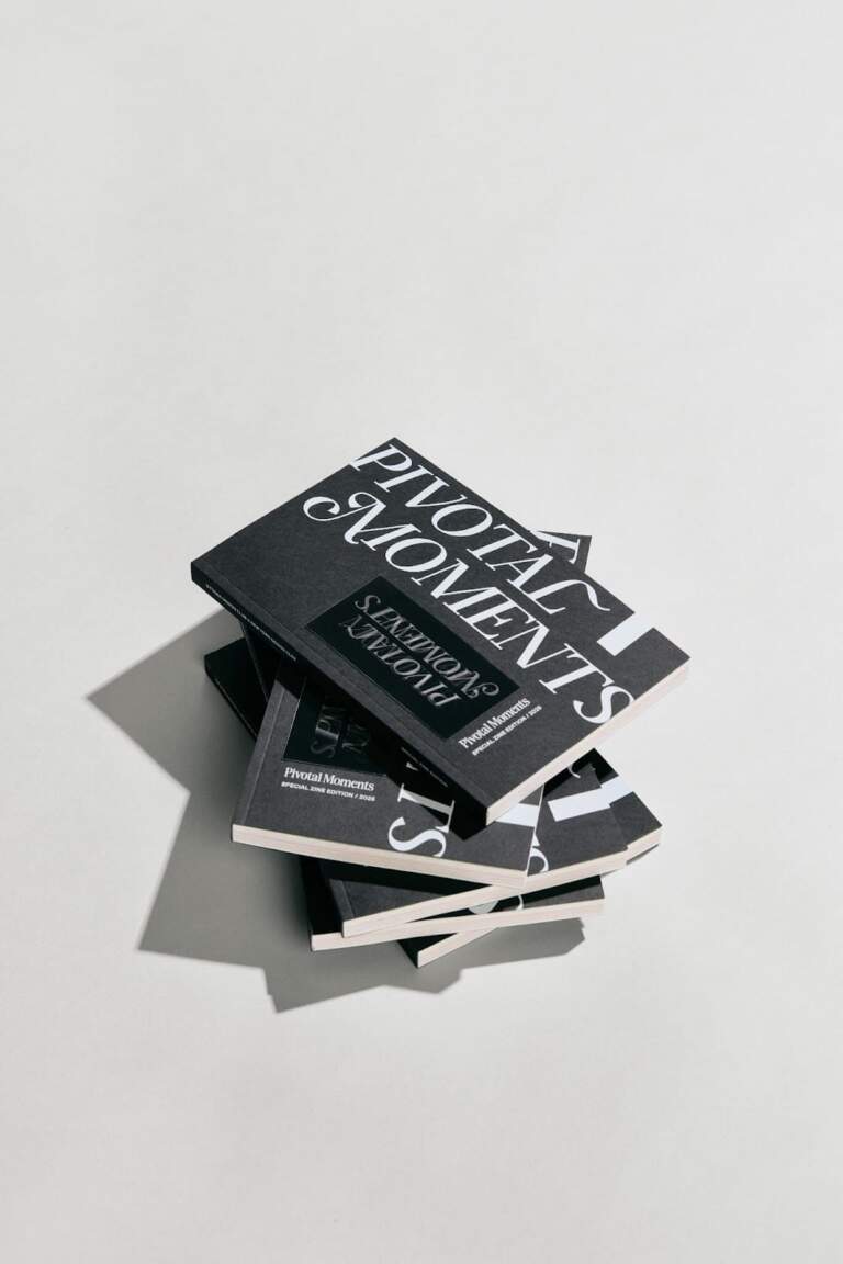 Image 1: Front cover of the Pivotal Moments book showcasing minimalist editorial design with specialty silver ink.