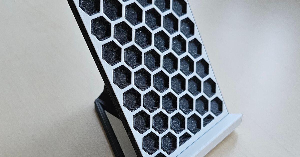 Image 1: 3D printed stand with hexagon pattern holding phone on desk