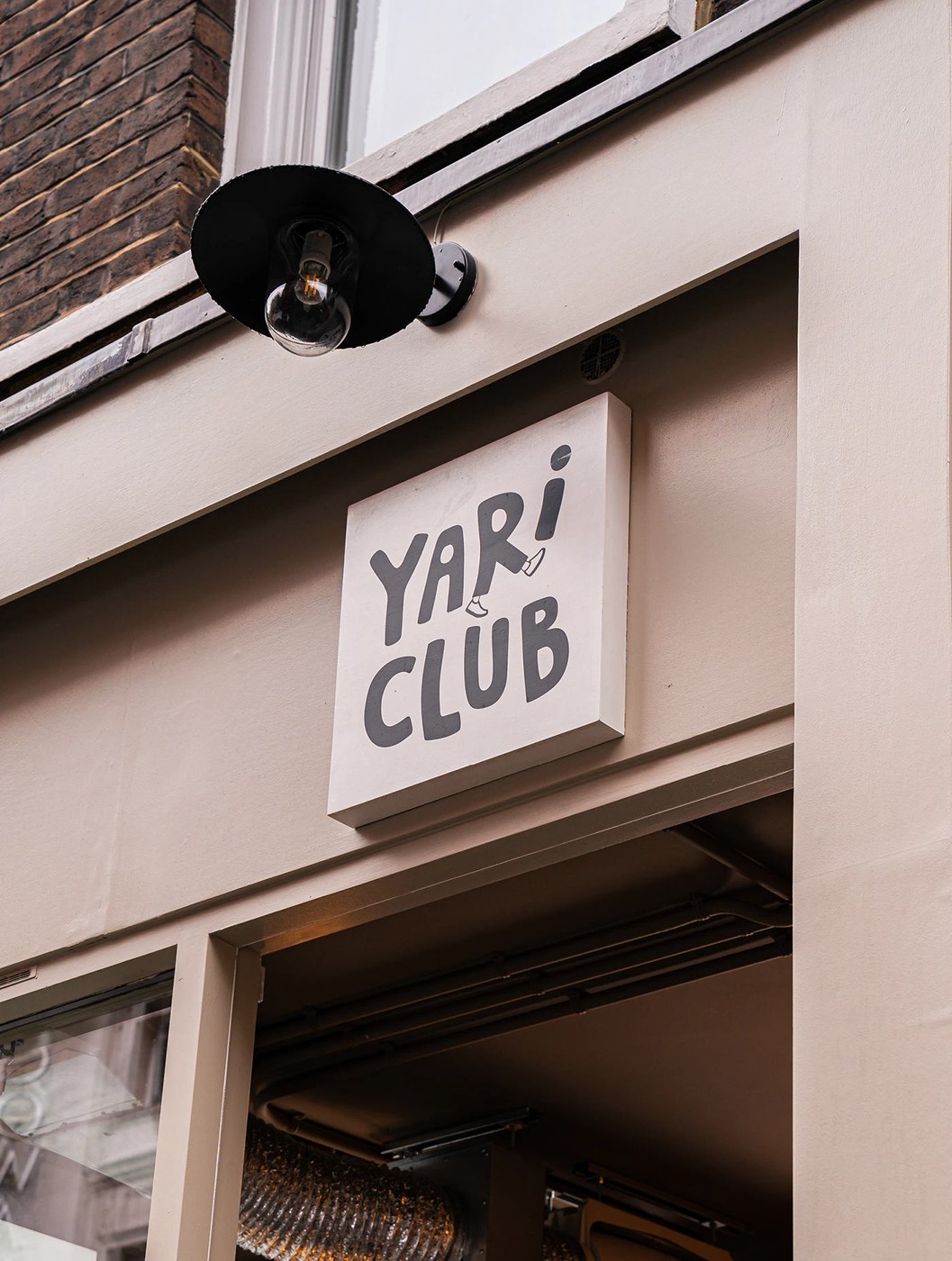 Image 1: YARI CLUB restaurant brand identity vertical wordmark logo on charcoal packaging box.