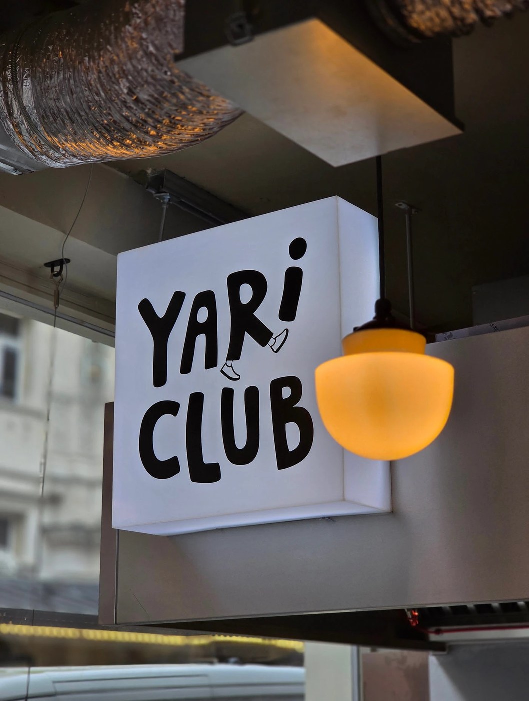 Image 8: YARI CLUB restaurant brand identity interior shop view featuring concrete structural beams.