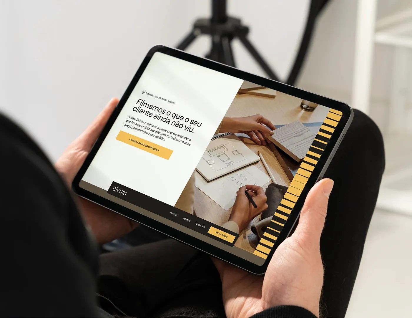 Image 5: Alvura Filmes branding tablet web portfolio interface held in hands