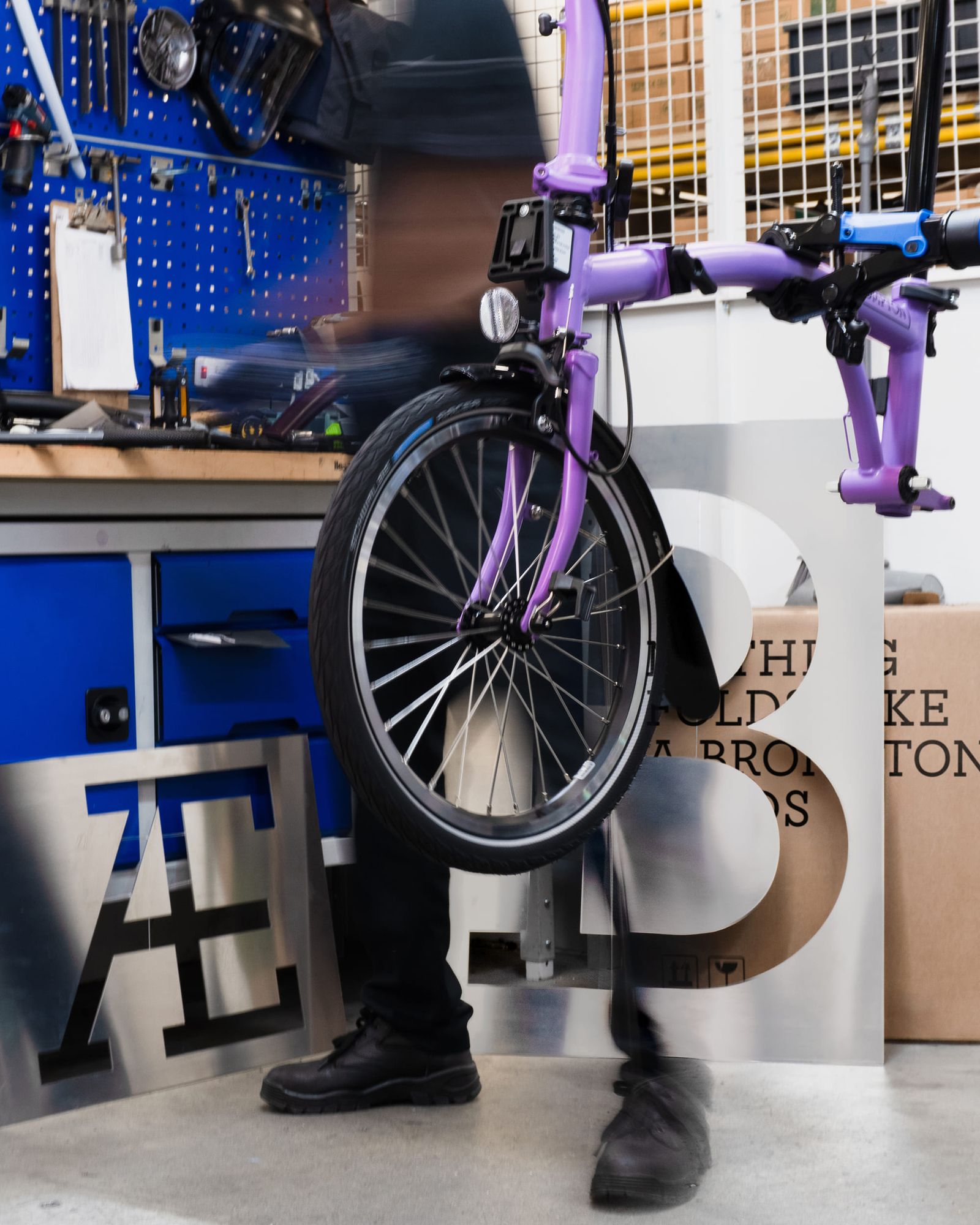 Image 7: Brompton global branding purple folding bike on assembly stand